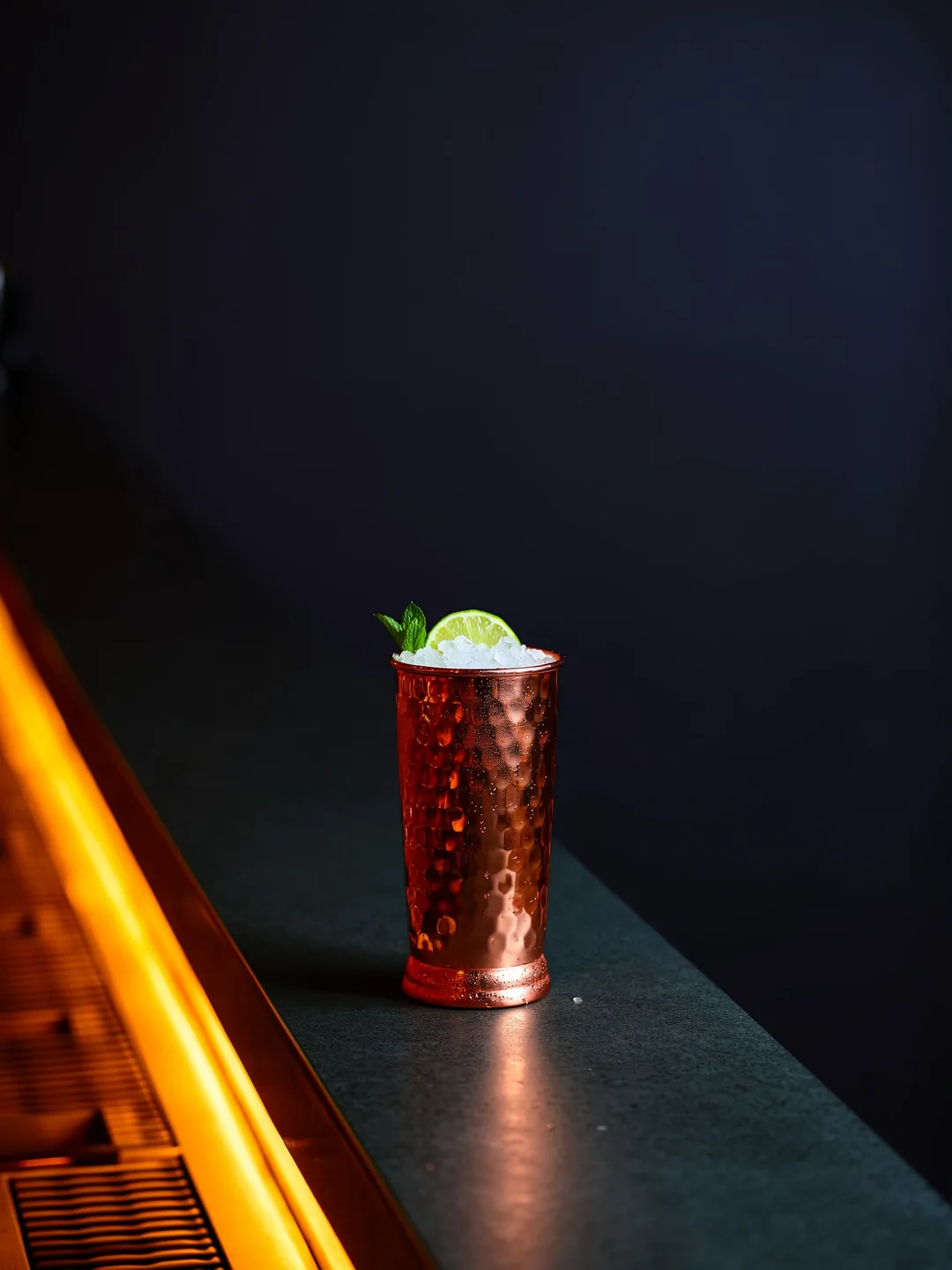 Moscow Mule in een koperen mok of highball op een donkere bar