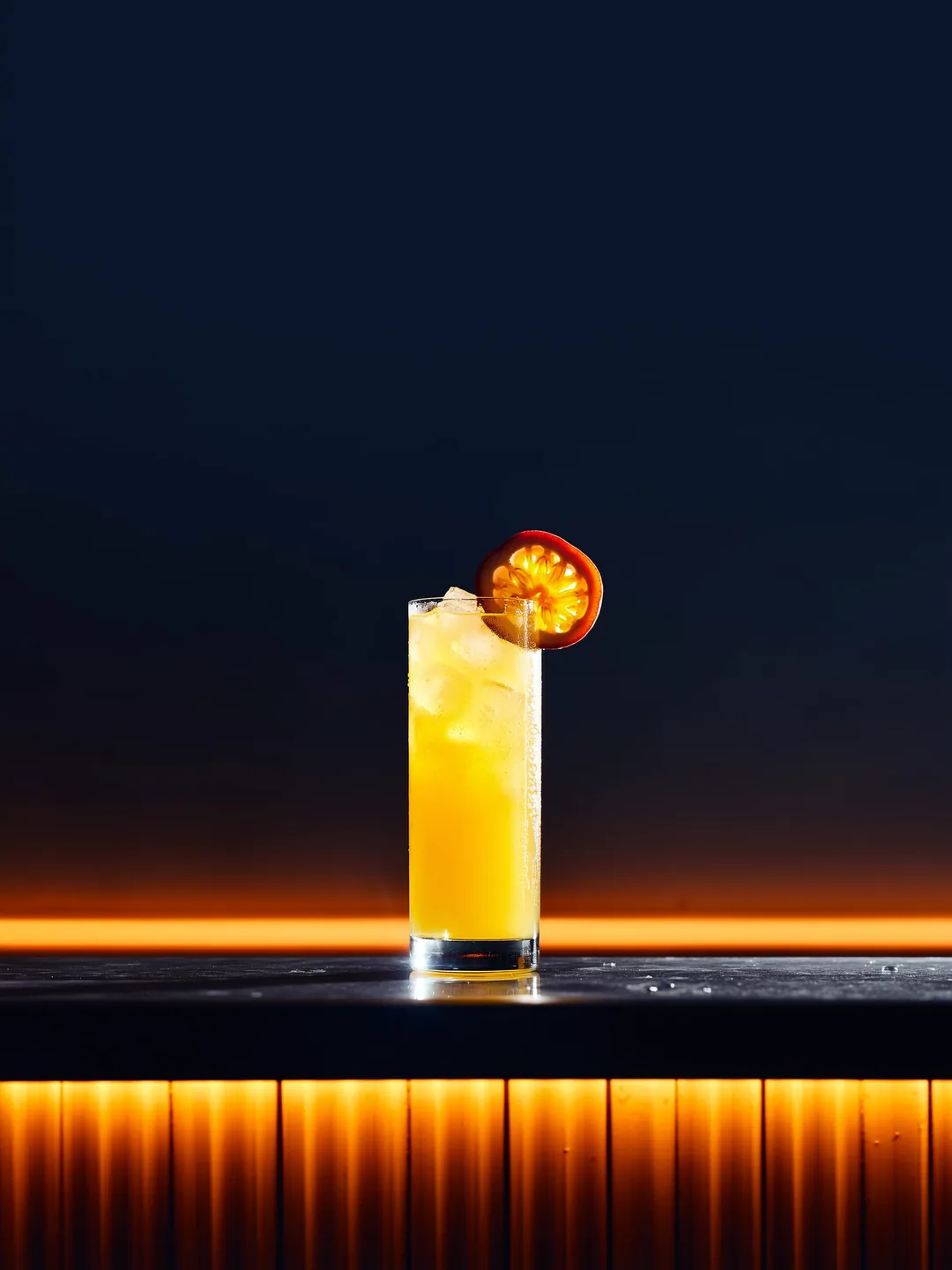 Passion Fizz in een coupe of highball op een donkere bar