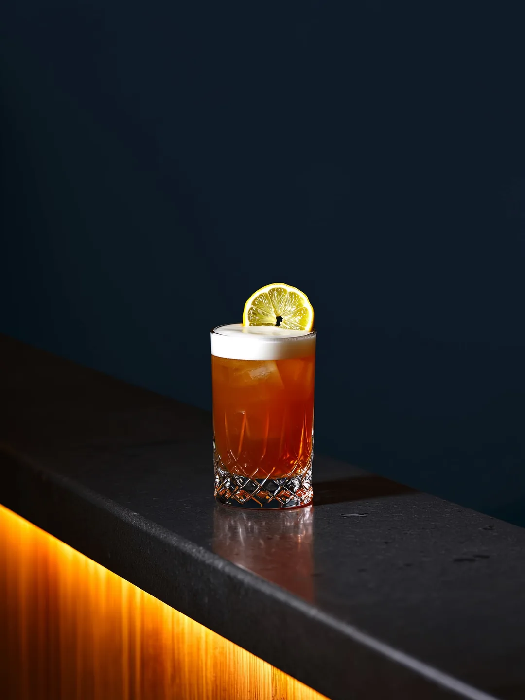 Whiskey Sour in een rocks glas op een donkere bar