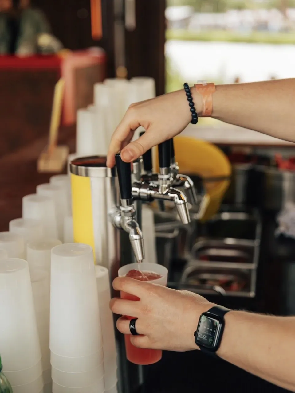 Een cocktail wordt getapt in een beker op een festivalbar
