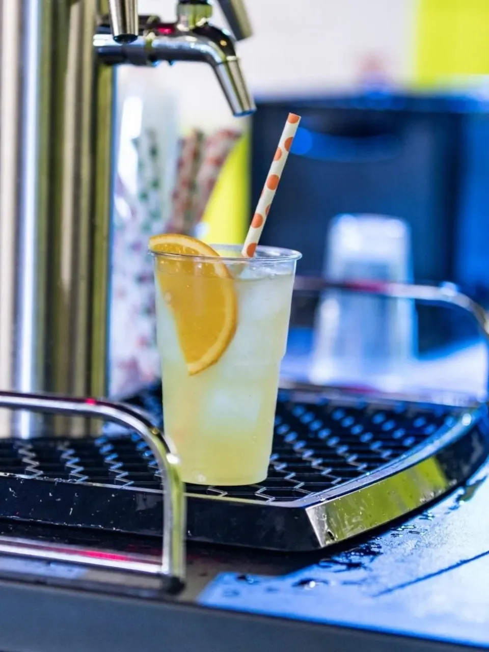 Een vers getapte cocktail met sinaasappel onder een tapkraan
